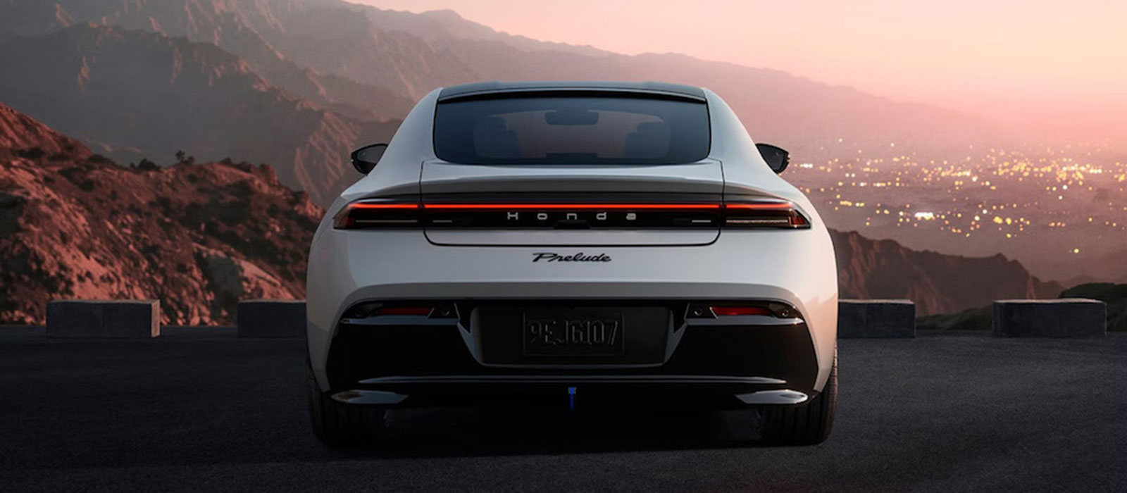 The back of a silver 2026 Honda Prelude sports car overlooking mountains at sunset