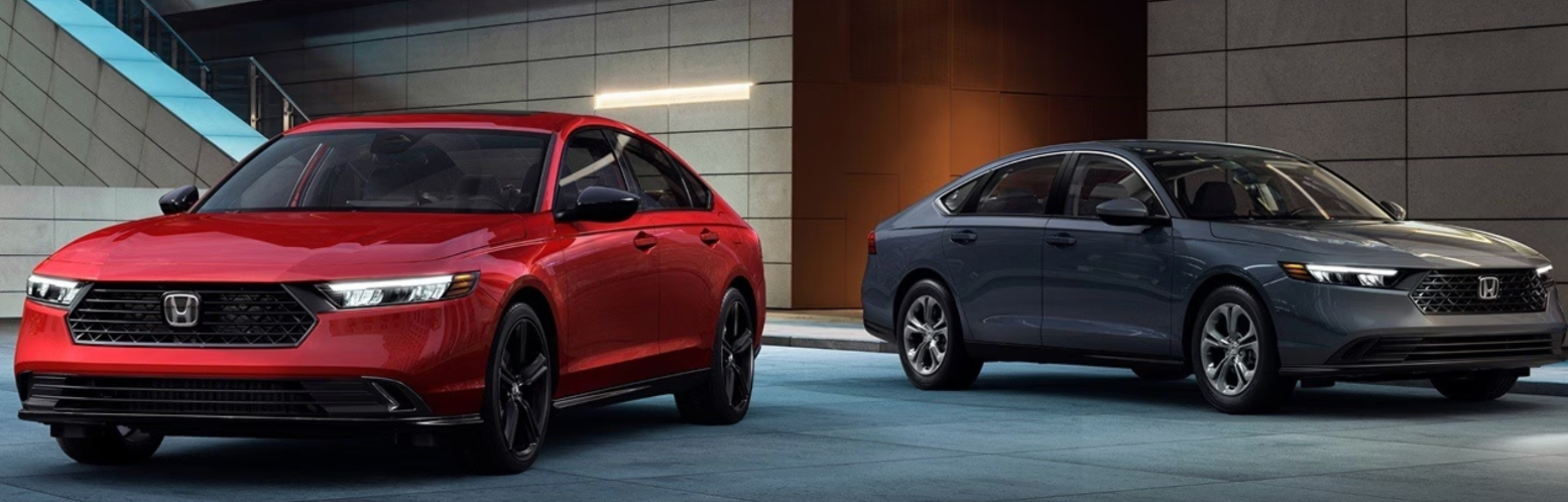 2026 Honda Accord Hybrid in red and gray parked in modern urban setting