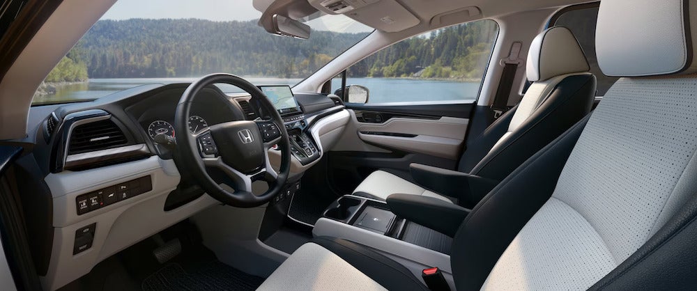 The interior of a 2026 Honda Odyssey with grey upholstery and a black steering wheel